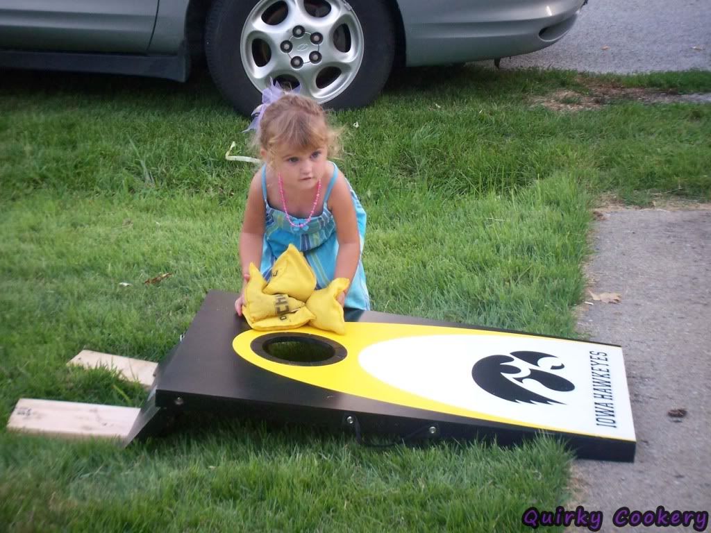 Little girl picking up bags for game of cornhole