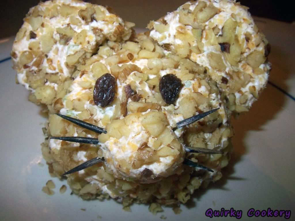 Cheeseball with cream cheese, cheddar cheese, walnuts, pecans shaped like a mouse with a toothpick nose