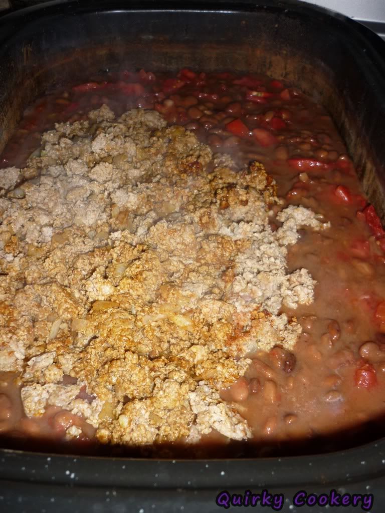 Adding meat to huge slow cooker of tomatoes and beans
