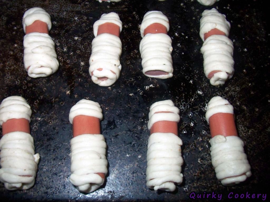 Halloween mummies made with hot dogs and refridgerated biscuit dough - uncooked pigs in the blanket