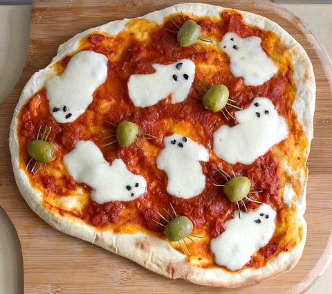 Pizza with mozarella cheese shaped like ghosts with black olive eyes. Spiders made of olives with rosemary legs.