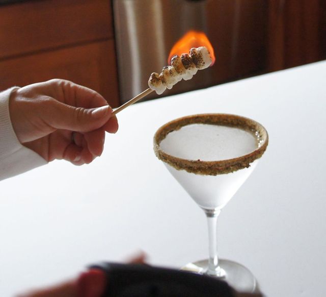 Smores martini. Chocolate and marshmallow vodkas with a chocolate and graham cracker dipped rim and flaming marshmallows on a stick. 