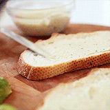 Gif of putting sandwich together with tomatoes, avocadoes, and bread