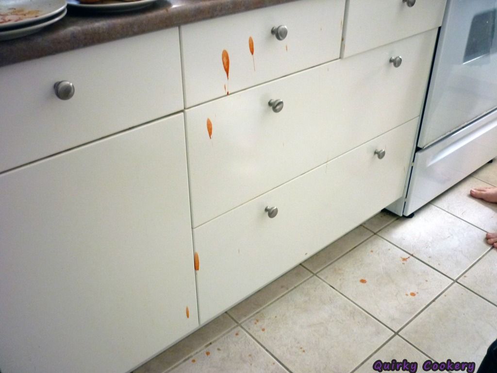 Picture of white cabinet drawers covered in catsup splatters from a bottle exploding. The pressure builds up and then how to get the red ketchup stain out? 