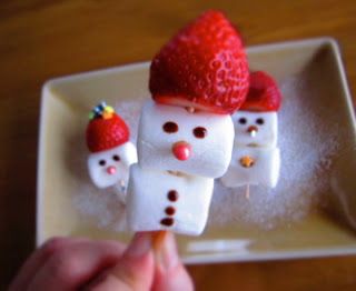 Marshmallows stacked on toothpicks with strawberry hats