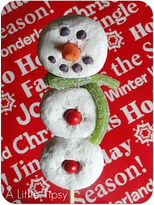 Three white doughnuts stacked on a popsicle stick to be made to look like snowmen