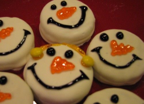 Oreos dipped in white chocolate to look like snowmen