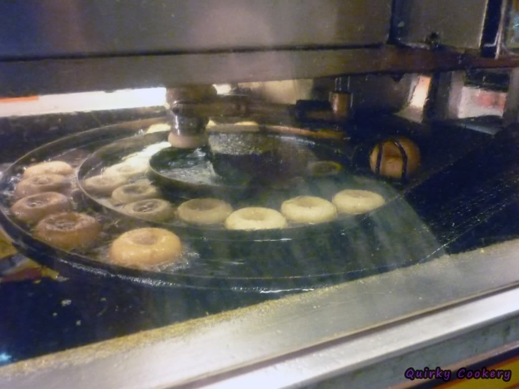Machine frying doughnuts in a circle fryer from Those Little Donuts