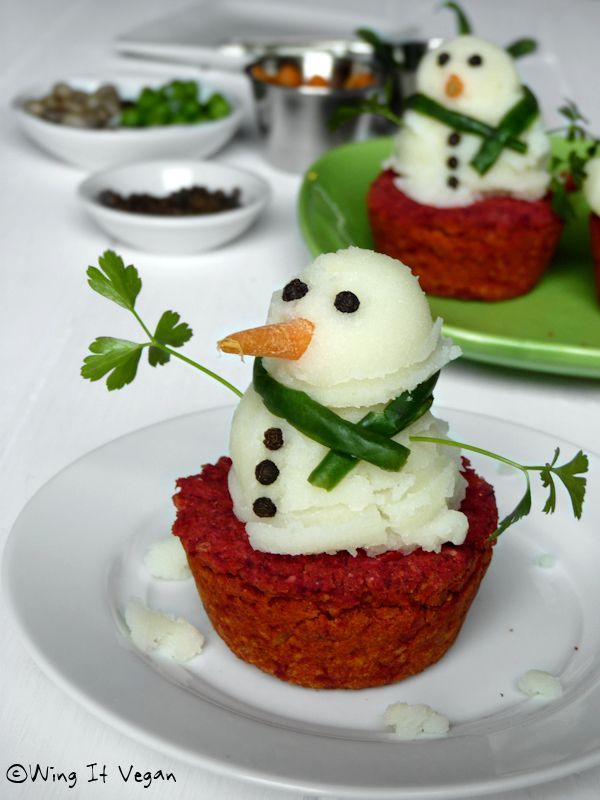 Vegan meatloaf with mashed potato snowman on top. Peppercorn eyes, pea buttons, steamed green bean scarf, and cilantro leaf arms with potato snowflakes on the plate.