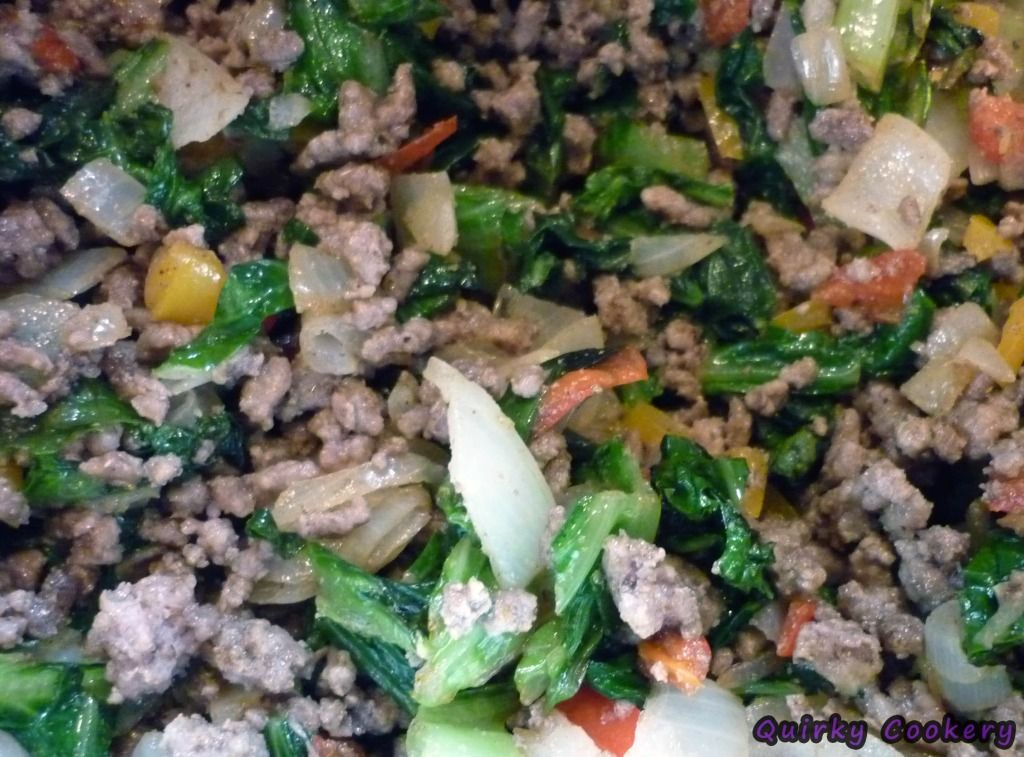 Cooked beef or pork rolls with wilted lettuce, onions, peppers, and seasonings all diced up in a bowl
