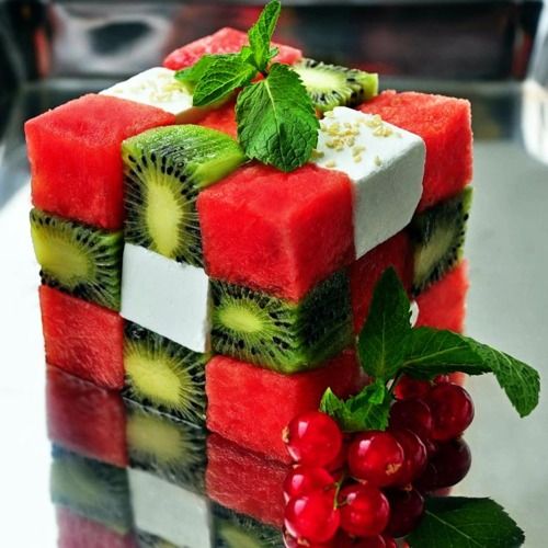 Christmas Rubik's Cube fruit dessert with kiwi, strawberry, feta cheese, and cranberry garnish