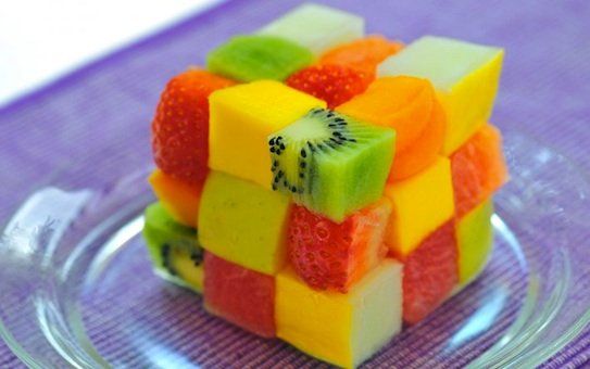 Rubik's cube fruit salad dessert using cubes of fresh cut fruit like kiwis, strawberries, apples, and mandarin oranges