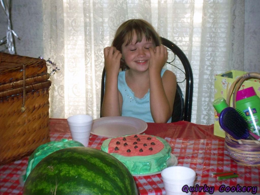 Child getting ready to blow out candles on watermelon cake