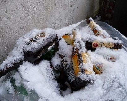 Bottles of frozen beer covered in ice in a cooler
