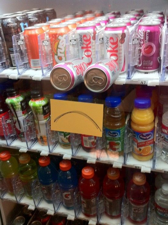 Crush, Diet Coke, Cherry Coke in a vending machine that is stuck and someone has made it into a frowny face. 